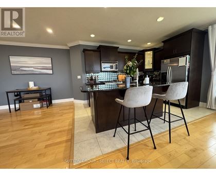 A modern kitchen with dark wood cabinets and a bar area.