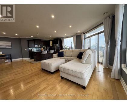 A living room with a white sofa and wooden flooring.