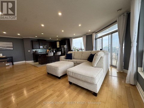 A living room with a white sofa and wooden flooring.