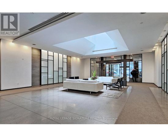 A spacious living room with a white sofa and a glass partition wall.