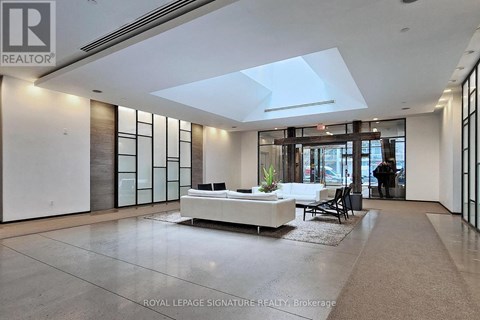 A spacious living room with a white sofa and a glass partition wall.