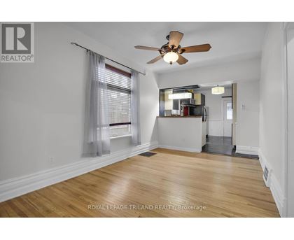 A room with a ceiling fan and wooden flooring.