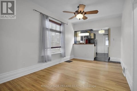 A room with a ceiling fan and wooden flooring.