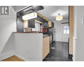 A kitchen with a white counter top and a black stove top oven.