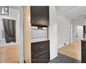 A kitchen with a wooden floor and a white wall.