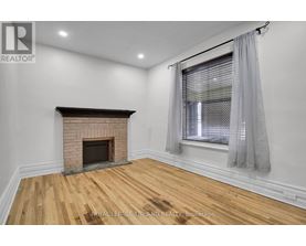 A room with a fireplace and wooden flooring.