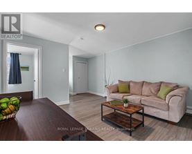 A living room with a couch, coffee table, and a bowl of fruit on the table.