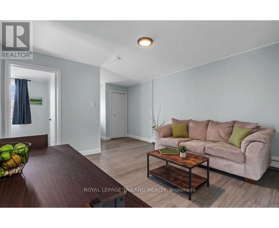 A living room with a couch, coffee table, and a bowl of fruit on the table.