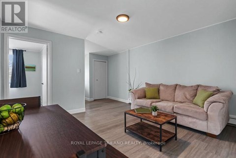 A living room with a couch, coffee table, and a bowl of fruit on the table.