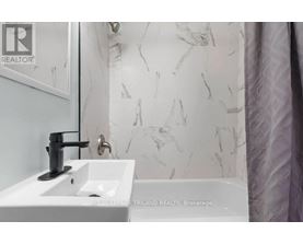A white sink with a black faucet in a bathroom.