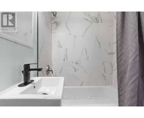 A white sink with a black faucet in a bathroom.