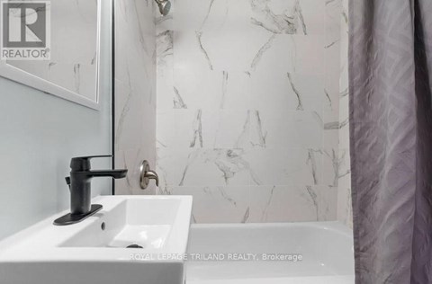 A white sink with a black faucet in a bathroom.