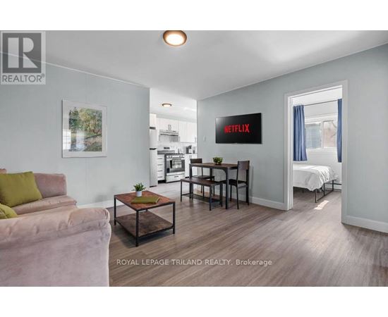 A living room with a couch, a coffee table, and a Netflix sign on the wall.