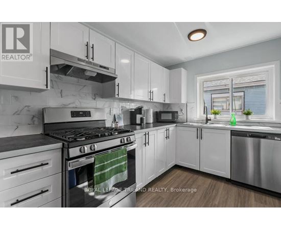 A modern kitchen with white cabinets and stainless steel appliances.