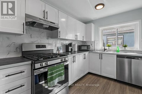 A modern kitchen with white cabinets and stainless steel appliances.