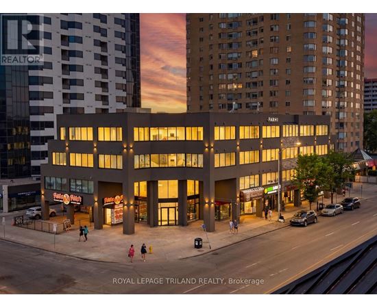 A building with the word "REALTOR" on it is lit up at dusk.