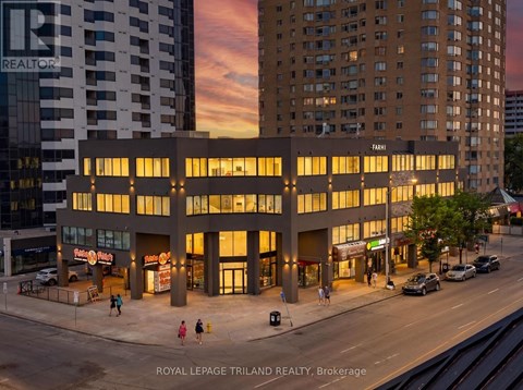 A building with the word "REALTOR" on it is lit up at dusk.