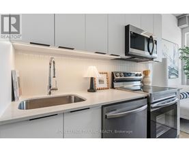 A modern kitchen with a stainless steel dishwasher and microwave above the stove.