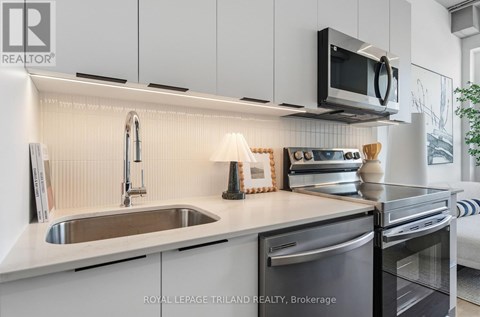 A modern kitchen with a stainless steel dishwasher and microwave above the stove.