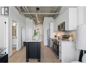 A modern kitchen with a black island in the middle.