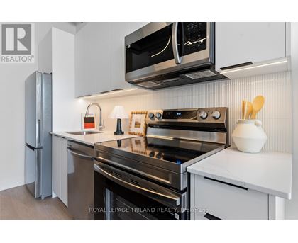 A modern kitchen with stainless steel appliances and white cabinetry.