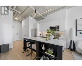 A modern kitchen with white cabinets and a black island.
