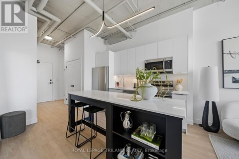A modern kitchen with white cabinets and a black island.