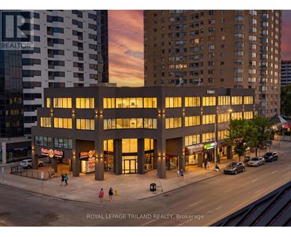 A building with the word "REALTOR" on it is lit up at dusk.