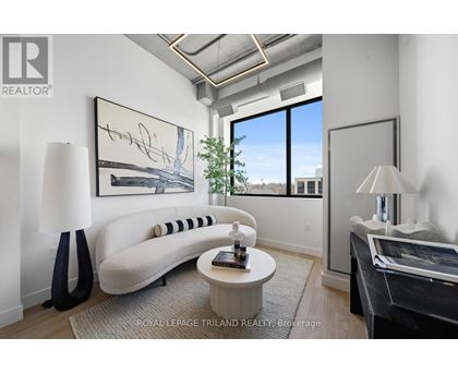 A well-lit, modern living room with a large window and a white sofa.
