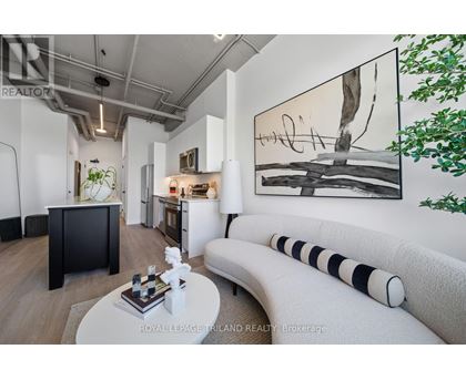 A modern living room with a large painting on the wall and a white sofa.