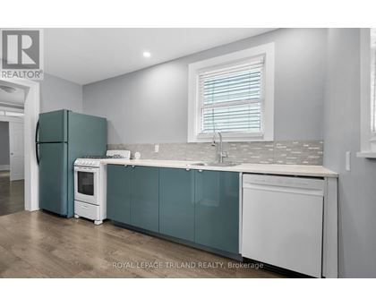 A kitchen with white appliances and a green fridge.