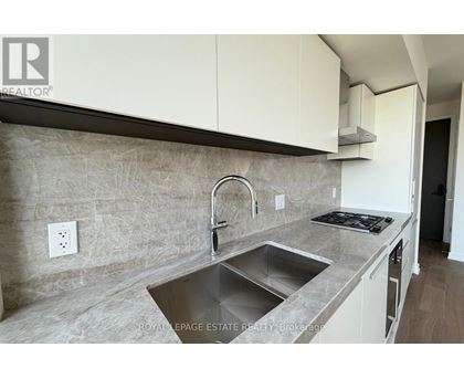 A kitchen with a sink and a stove top.