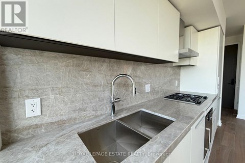 A kitchen with a sink and a stove top.