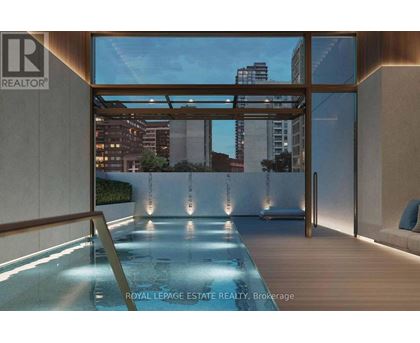 A modern indoor swimming pool with a view of the city.