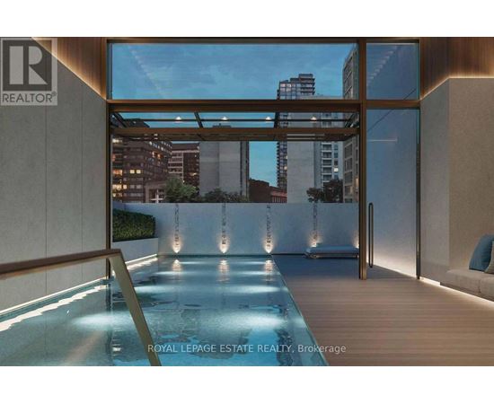 A modern indoor swimming pool with a view of the city.