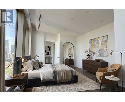 A bedroom with a large bed, a chair, and a painting on the wall.