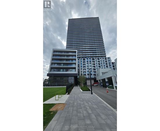 A tall building with a glass facade stands next to a shorter building with a white facade.