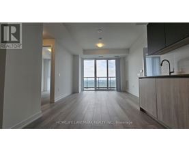 A spacious kitchen with a sink and a window overlooking the balcony.