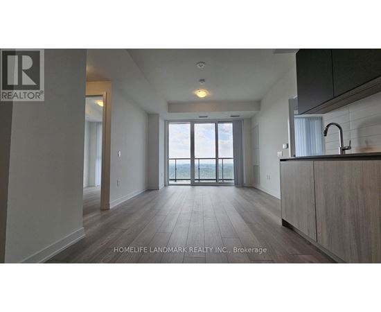 A spacious kitchen with a sink and a window overlooking the balcony.