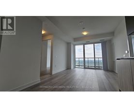 A spacious room with a view of the outdoors through large windows.