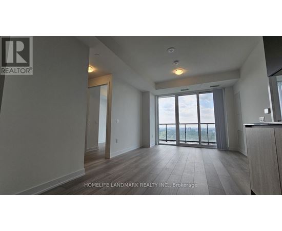 A spacious room with a view of the outdoors through large windows.
