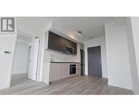 A modern kitchen with a wooden floor and white walls.