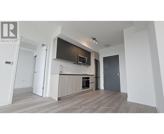 A modern kitchen with a wooden floor and white walls.