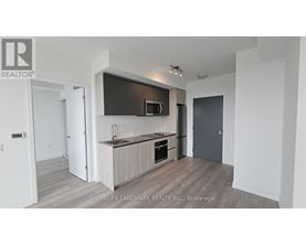 A modern kitchen with a wooden floor and white walls.
