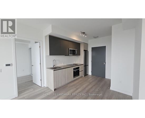 A modern kitchen with a wooden floor and white walls.