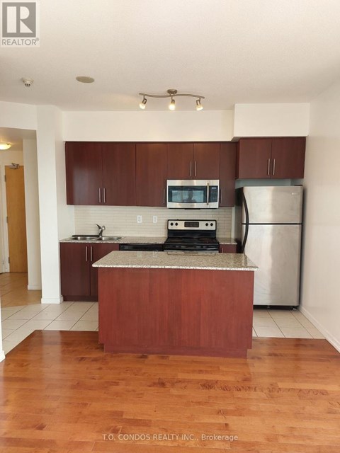 A kitchen with wooden cabinets and a granite countertop.