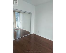 A room with a sliding glass door and wood flooring.