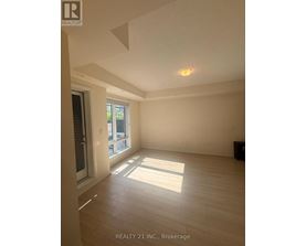 A room with a window and a door, with a sign that says REALTY 21 INC., Brokerage.