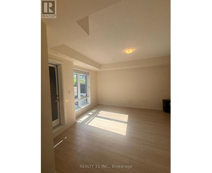 A room with a window and a door, with a sign that says REALTY 21 INC., Brokerage.