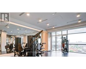A gym with a row of treadmills and a row of stationary bikes.